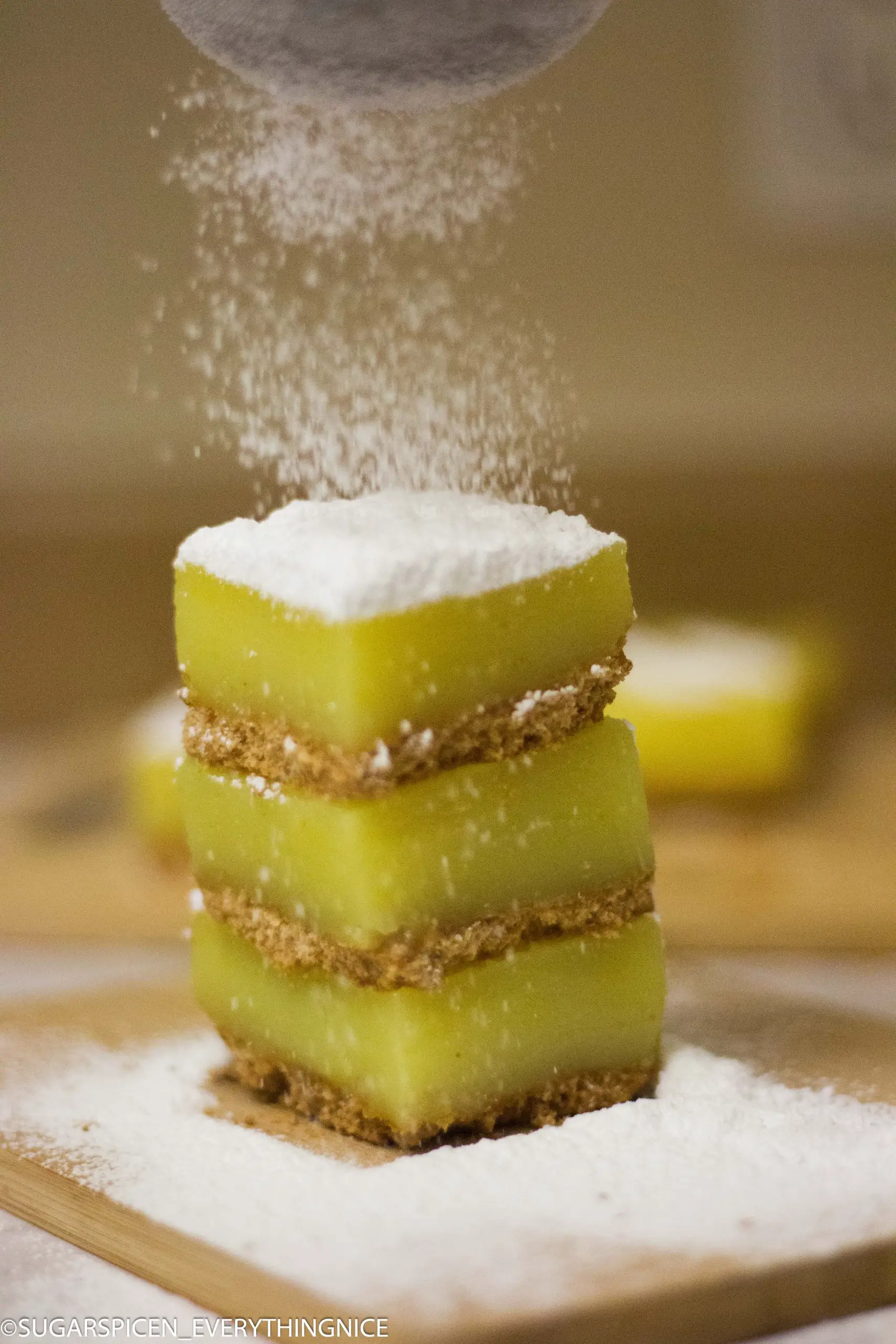 Three squares of lemon bars with powdered sugar dusting