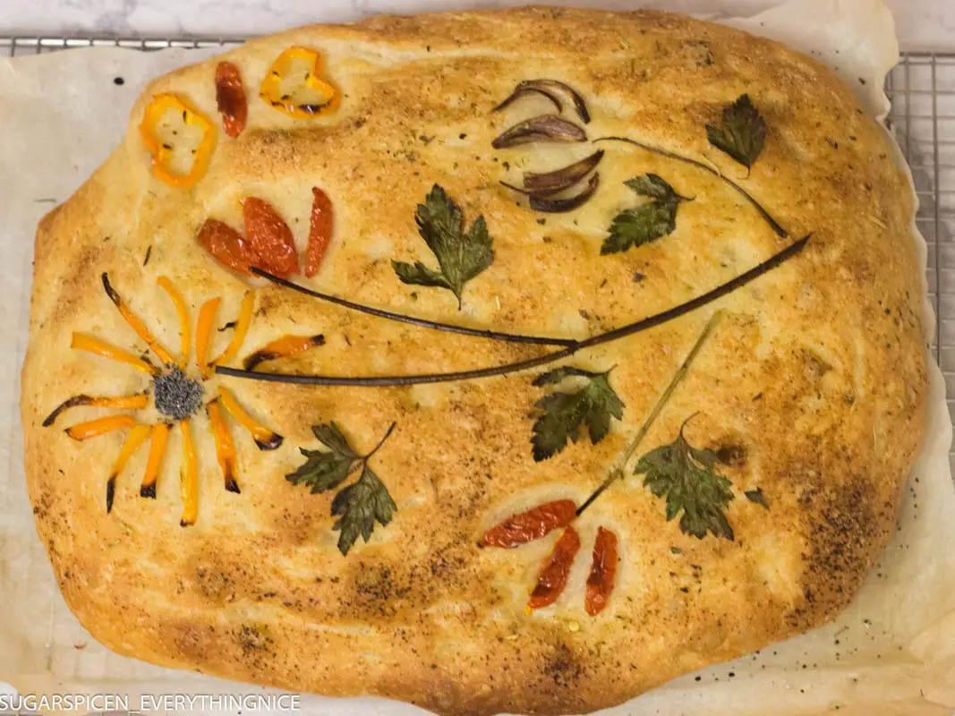 Focaccia decorated with herbs and toppings