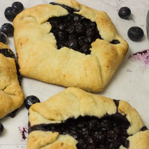 3 mini blueberry galettes with blueberries around