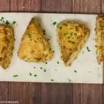 4 cheddar and chives scones kept on a marble board