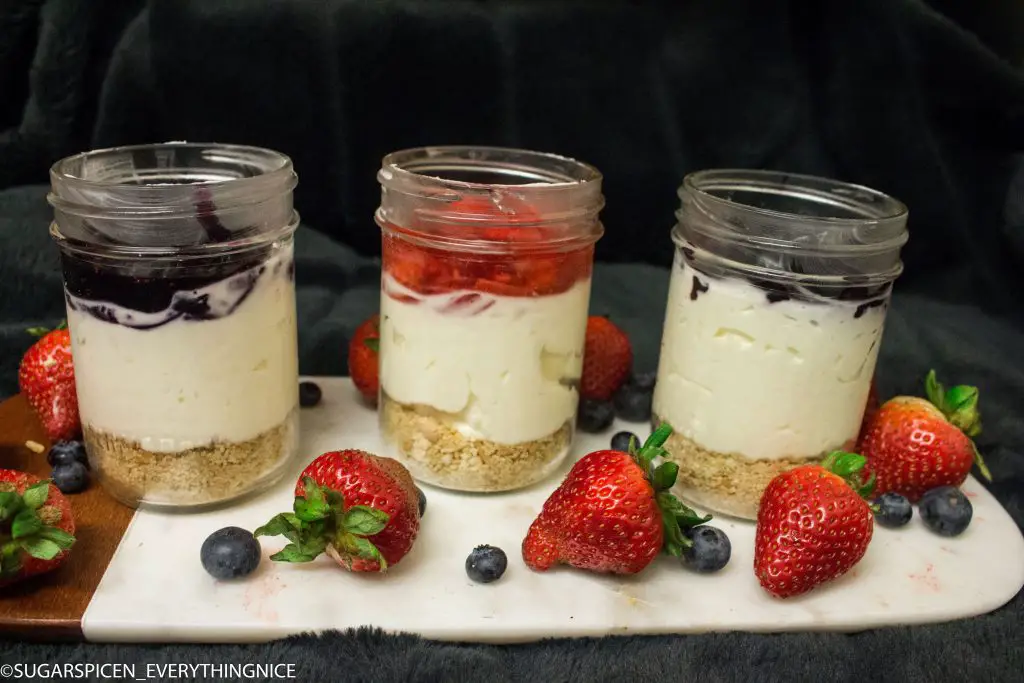 3 cheesecake in a jar with bluberry and strawberry toppings