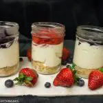 3 cheesecake in a jar with bluberry and strawberry toppings