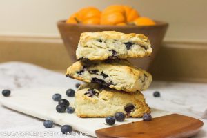 Starbucks Blueberry Scone Recipe (Copycat) 3 blueberry scones with blueberry spread around it.