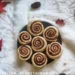 A plate of cinnamon rolls with fall leaves around