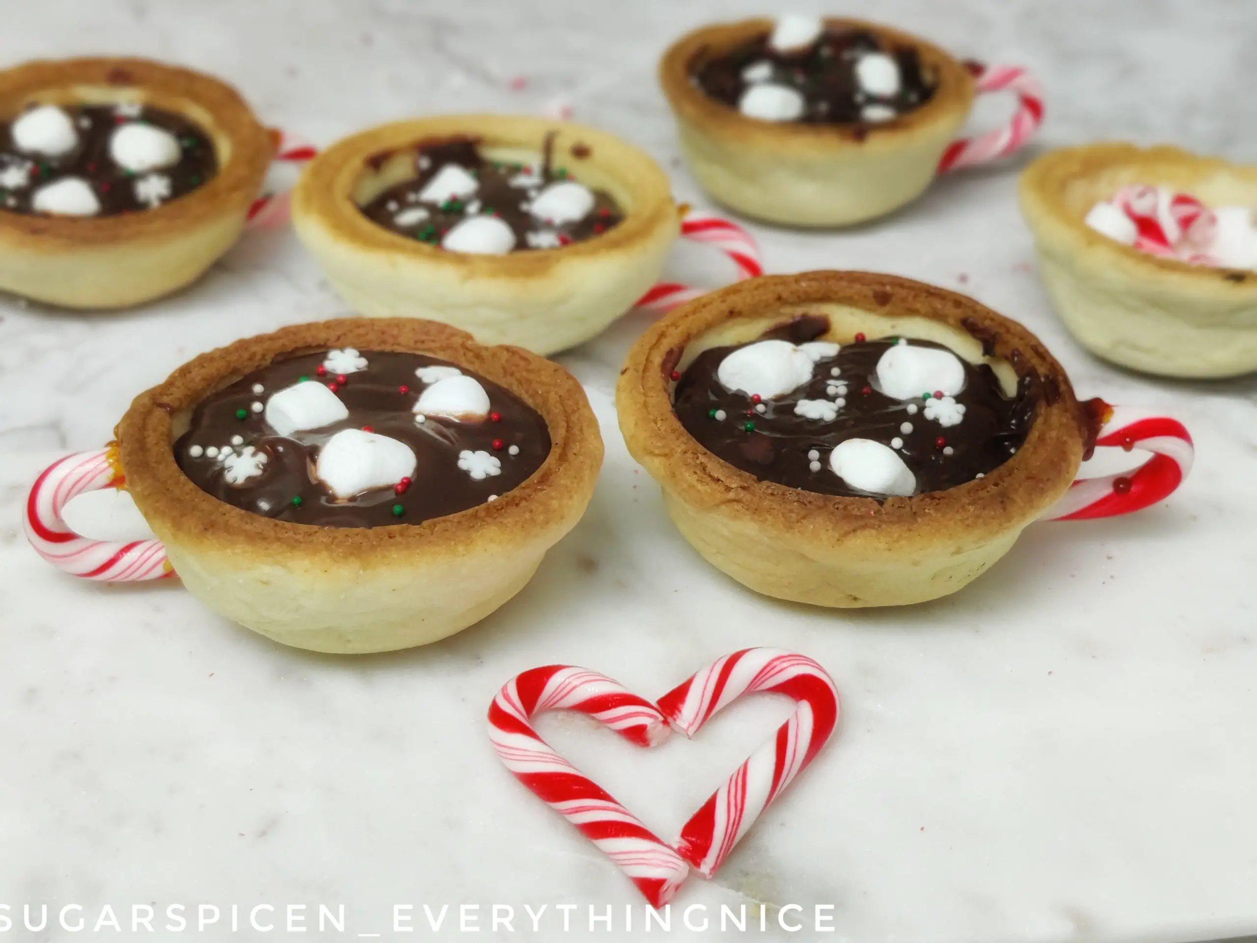 2 hot chocolate cookie cups and a candy cane heart