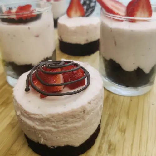 Strawberry Mousse over Chocolate Cake with strawberry pieces on top with frozen chocolate design