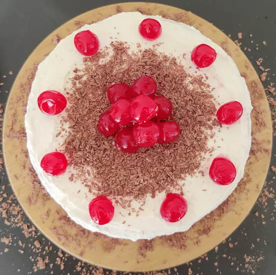 decorate the cake with cherries and chocolate shavings