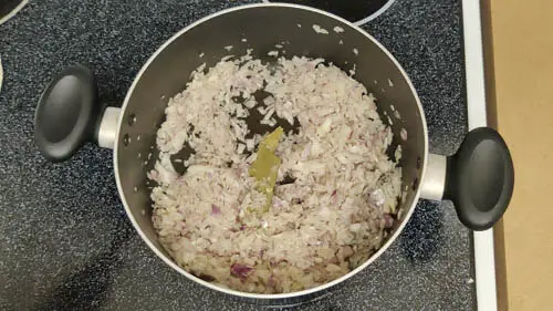 onion and bay leaf added to pot on medium heat