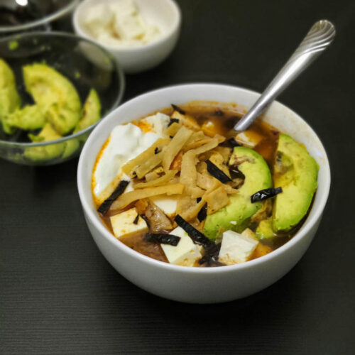 sopa de tortilla on a white bowl