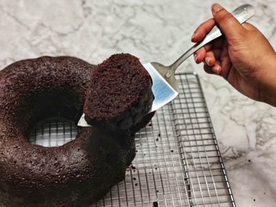 a cut slice of bundt chocolate cake held up