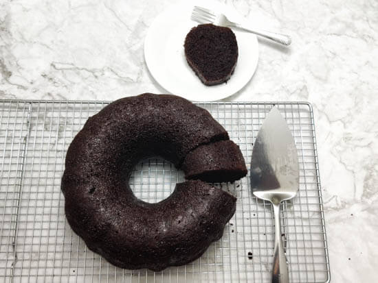 bundt chocolate rum cake cut with one piece placed on a plate