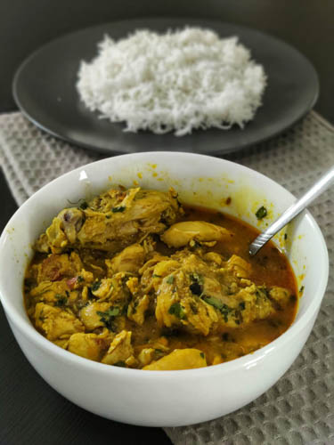 chicken salan in a white bowl served with basmati rice