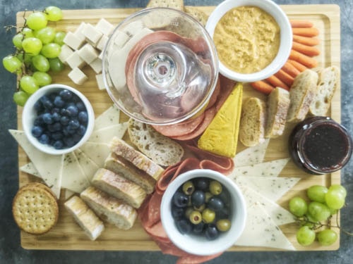 adding fruits, bread and crackers to the board