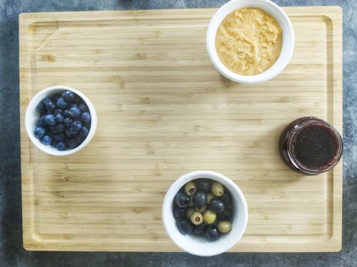 add bowls of blueberries, hummus, olives and raspberry jam