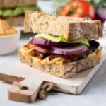 Vegan BLT sandwich on a wooden slab