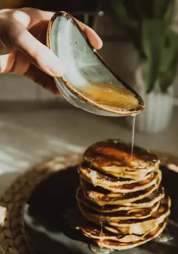 maple syrup poured over pancake stack