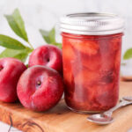 plum compote in a jar with plums kept on the side