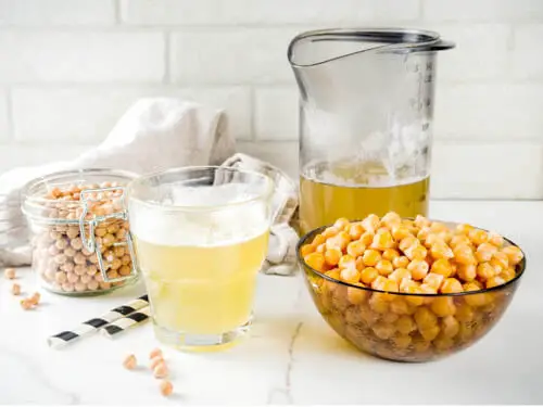 aquafaba in a glass container and chickpeas kept on the side