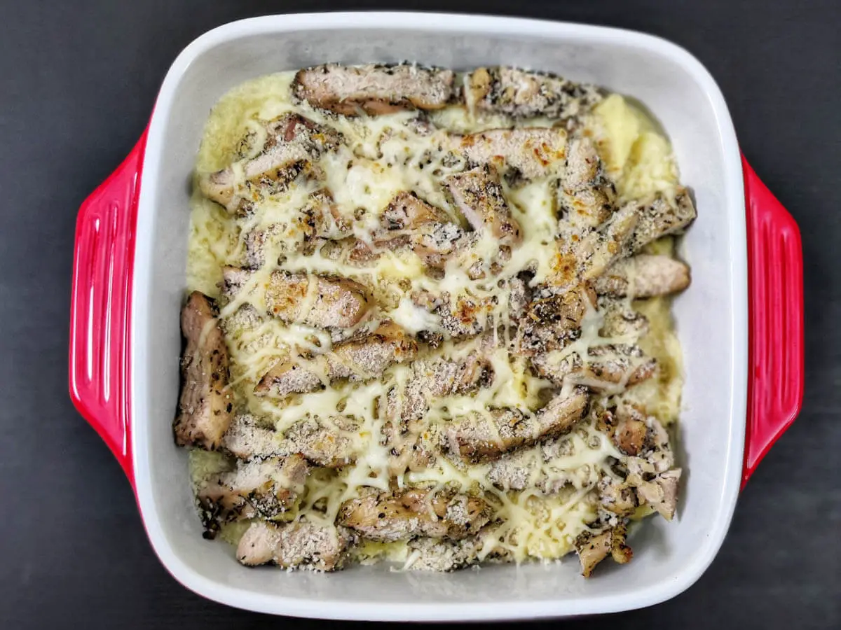 asiago tortelloni alfredo with grilled chicken in an oven safe red dish.
