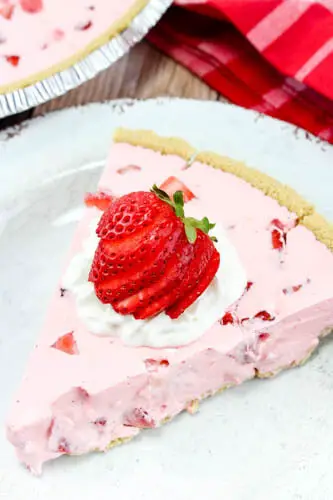 strawberry shortcake slice with whipped cream and cut strawberry on top