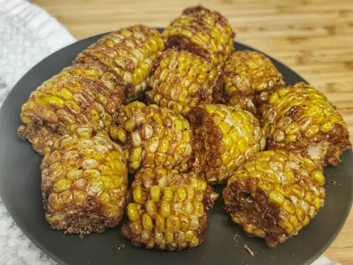 deep fried corn with cajun seasoning on a black plate