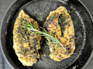 Texas Roadhouse Herb Crusted Chicken (Copycat Recipe) texas roadhouse herb crusted chicken on a cast iron skillet