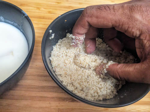 coating the pasta with breadcrumbs in a bowl