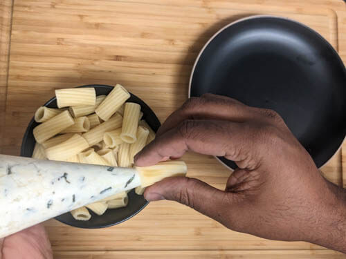 piping the cheese mixture into the pasta