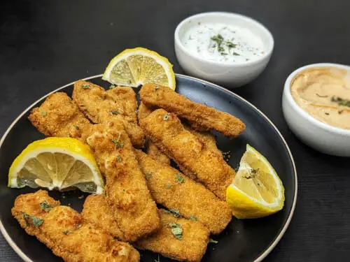 gorton's fish sticks served on a black plate and served with a side of ranch and chipotle dipping sauce