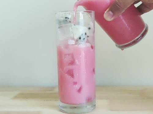 pouring dragon drink to tall glass over ice