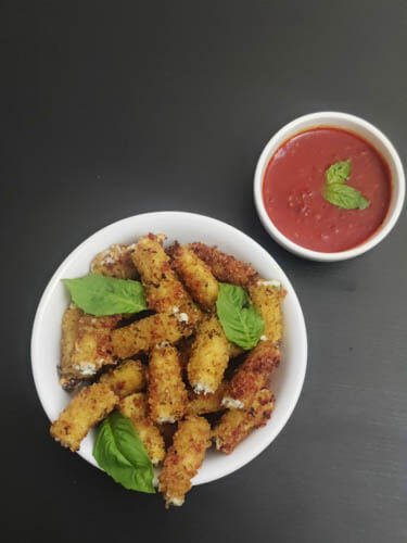 stuffed ziti fritta in white bowl served with a side of marinara sauce