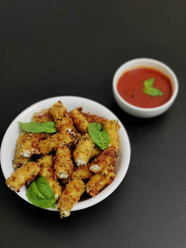stuffed ziti fritta in white bowl served with a side of marinara sauce
