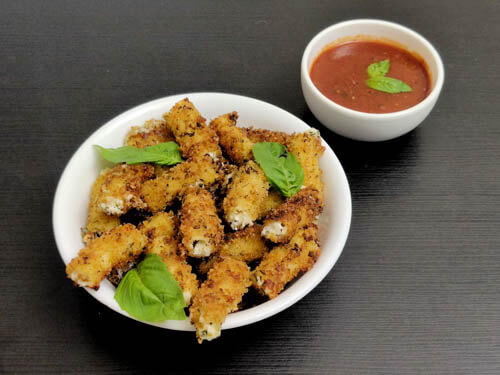 stuffed ziti fritta in white bowl served with a side of marinara sauce