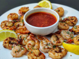 Easy Bloves Sauce Recipe (Smackalicious Seafood Sauce) blove sauce in a white bowl placed on a white plate with fried shrimps