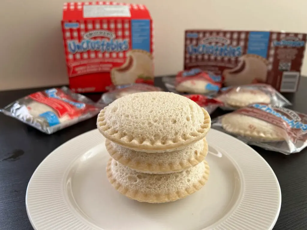 uncrustables stacked up on a white plate